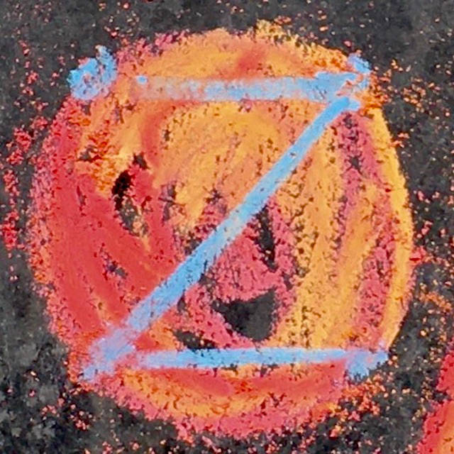 fiery red and ice blue dotZero symbol roughly scrawled in chalk